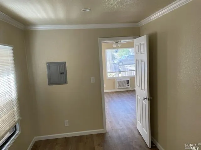 a view of a hallway with wooden floor and a bathroom