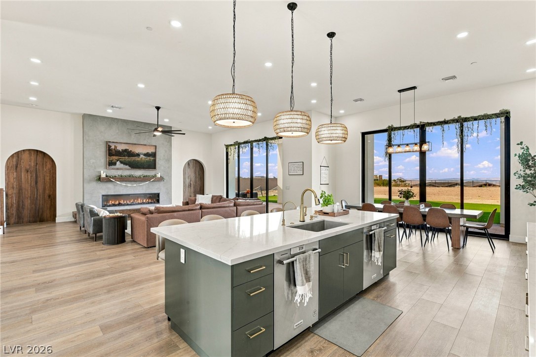 324 Wanda Road Henderson, NV 89002 - Photo 17 of 96 An open-concept layout connects the kitchen to living and dining areas framed by massive windows.