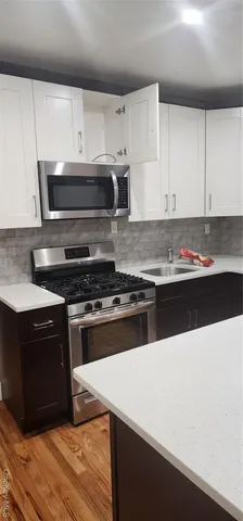 a kitchen with stainless steel appliances a stove a sink and a microwave
