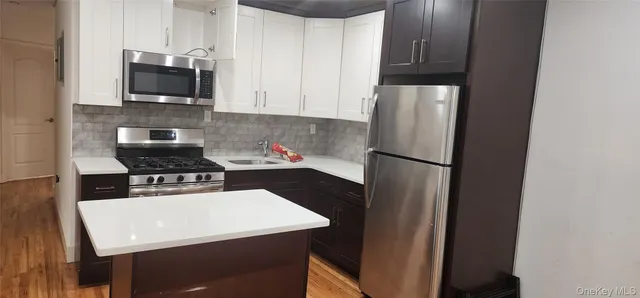 a kitchen with stainless steel appliances a refrigerator a stove a microwave and cabinets