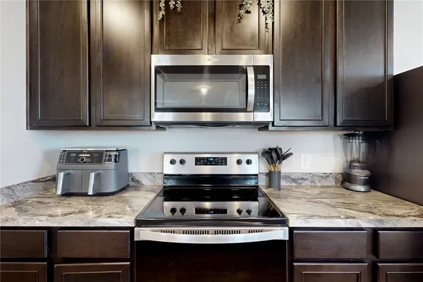 a kitchen with granite countertop a stove and a microwave