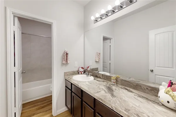 a bathroom with a granite countertop sink and a mirror