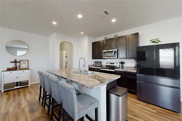 a kitchen with granite countertop a center island stainless steel appliances and cabinets