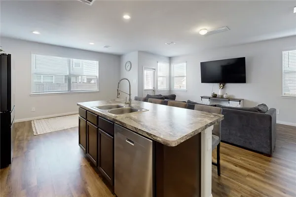 a kitchen with a sink and a wooden floor