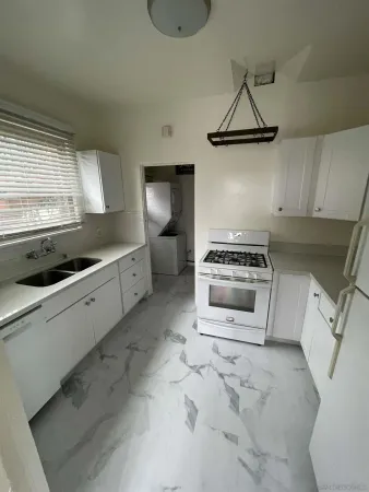 a kitchen with stainless steel appliances a stove a sink and a refrigerator