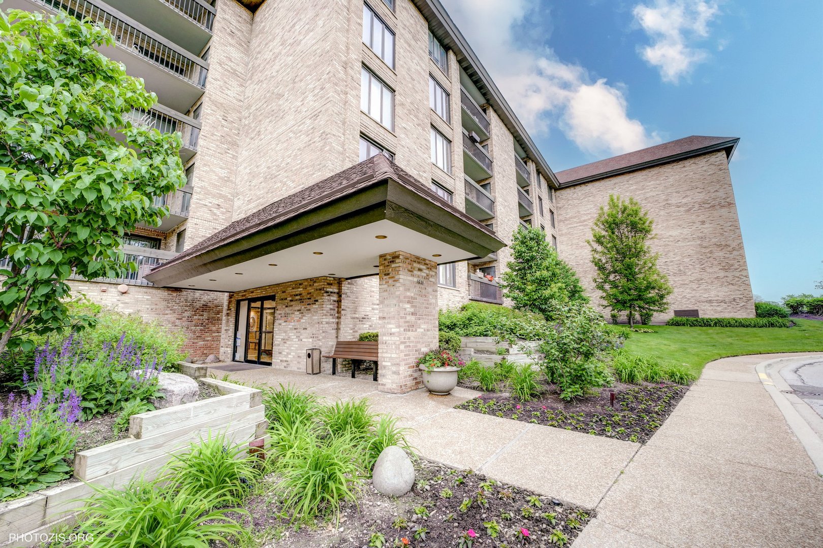 1621 Mission Hills Road, Unit 108 Northbrook, IL 60062 - Photo 1 of 22 a view of a house with brick walls plants and large tree