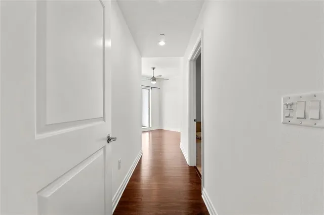 a view of a hallway with wooden floor and staircase