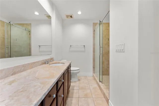 a bathroom with a granite countertop sink a toilet and shower