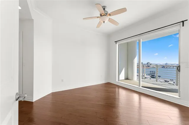 a view of a room with wooden floor and a floor to ceiling window