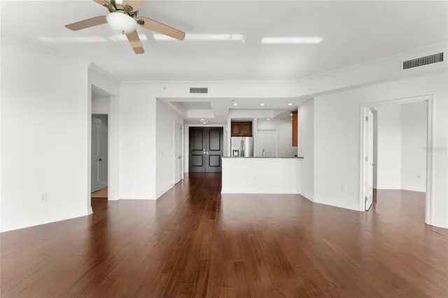 a view of a kitchen with wooden floor a sink a refrigerator and window