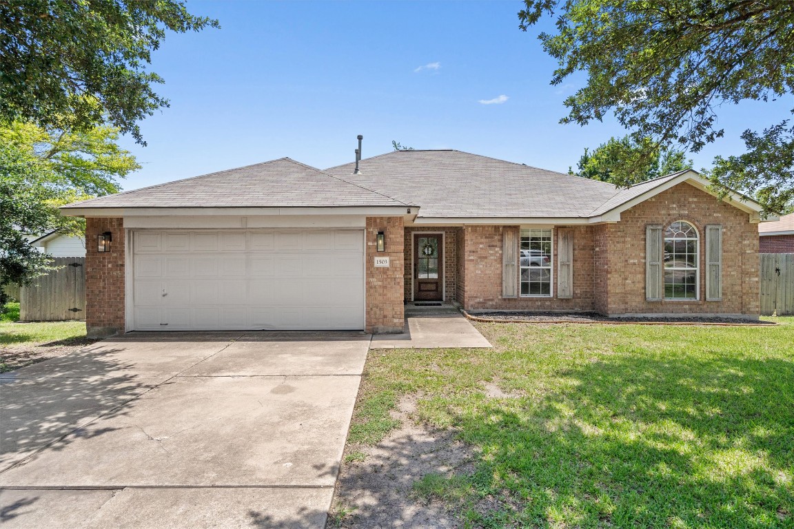 a front view of a house with a garden and yard