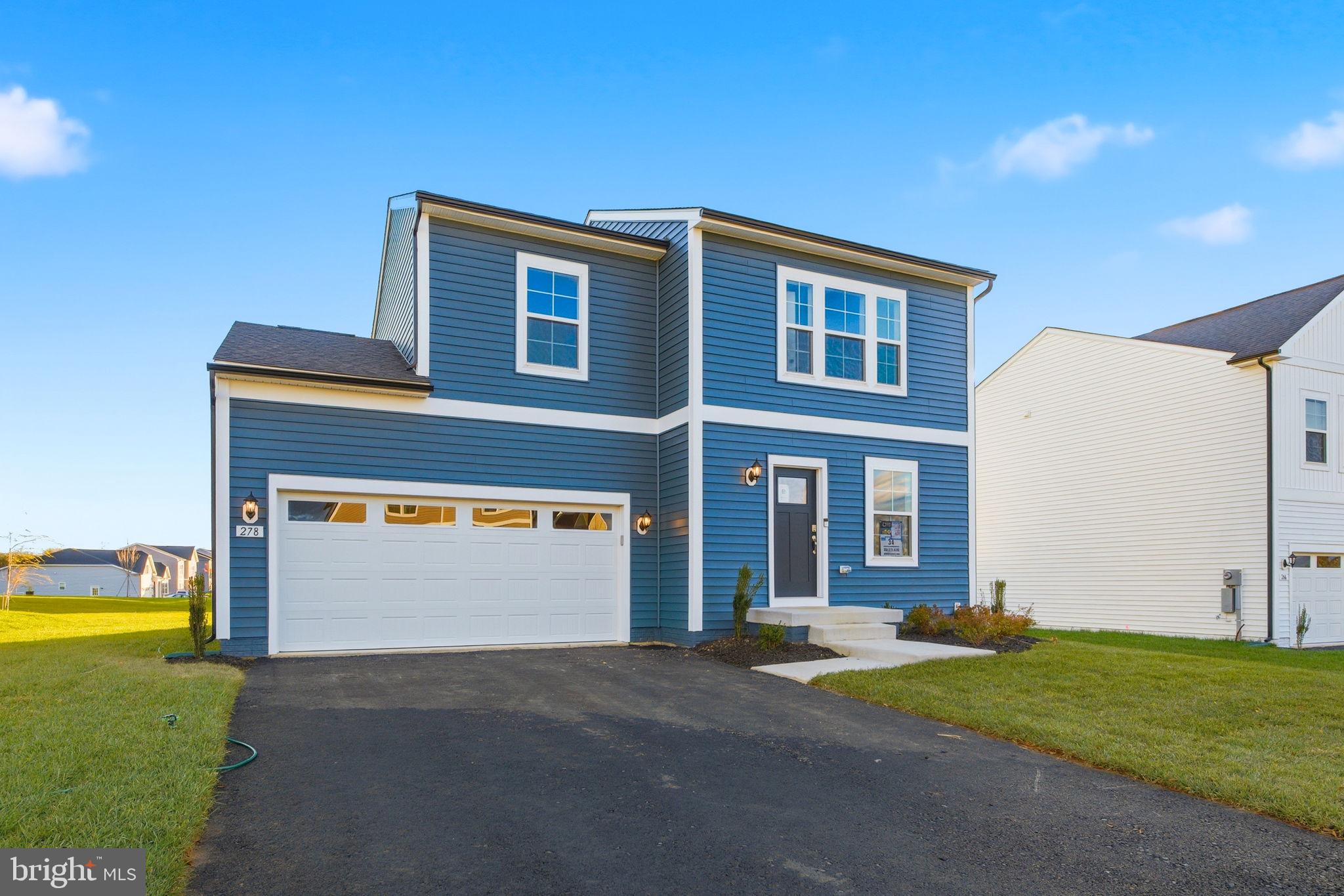 Tbb Tbb Outrigger Road, Unit WEXFORD Inwood, WV 25428 - Photo 2 of 34 a front view of a house with a yard and garage