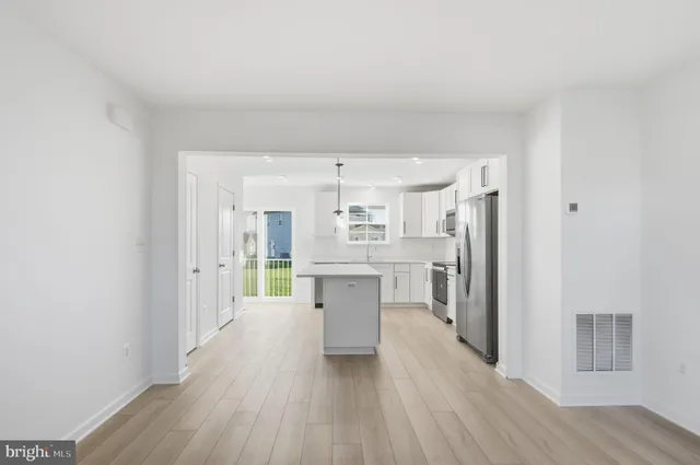 a large kitchen with a wooden floor and stainless steel appliances