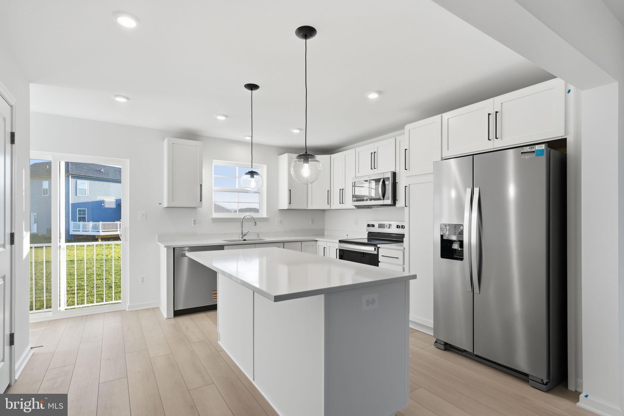 Tbb Tbb Outrigger Road, Unit WEXFORD Inwood, WV 25428 - Photo 5 of 34 a kitchen with stainless steel appliances granite countertop a refrigerator a sink dishwasher a stove and a refrigerator with wooden floor