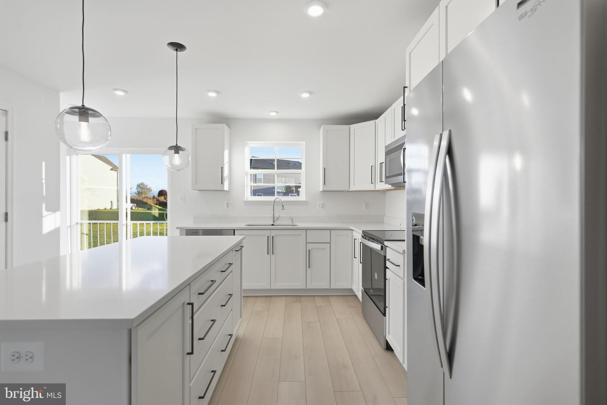 Tbb Tbb Outrigger Road, Unit WEXFORD Inwood, WV 25428 - Photo 7 of 34 a kitchen with white cabinets and stainless steel appliances