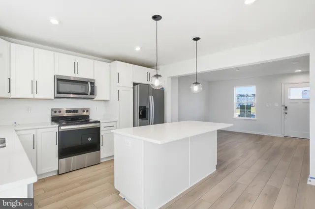 a kitchen with kitchen island white cabinets and stainless steel appliances