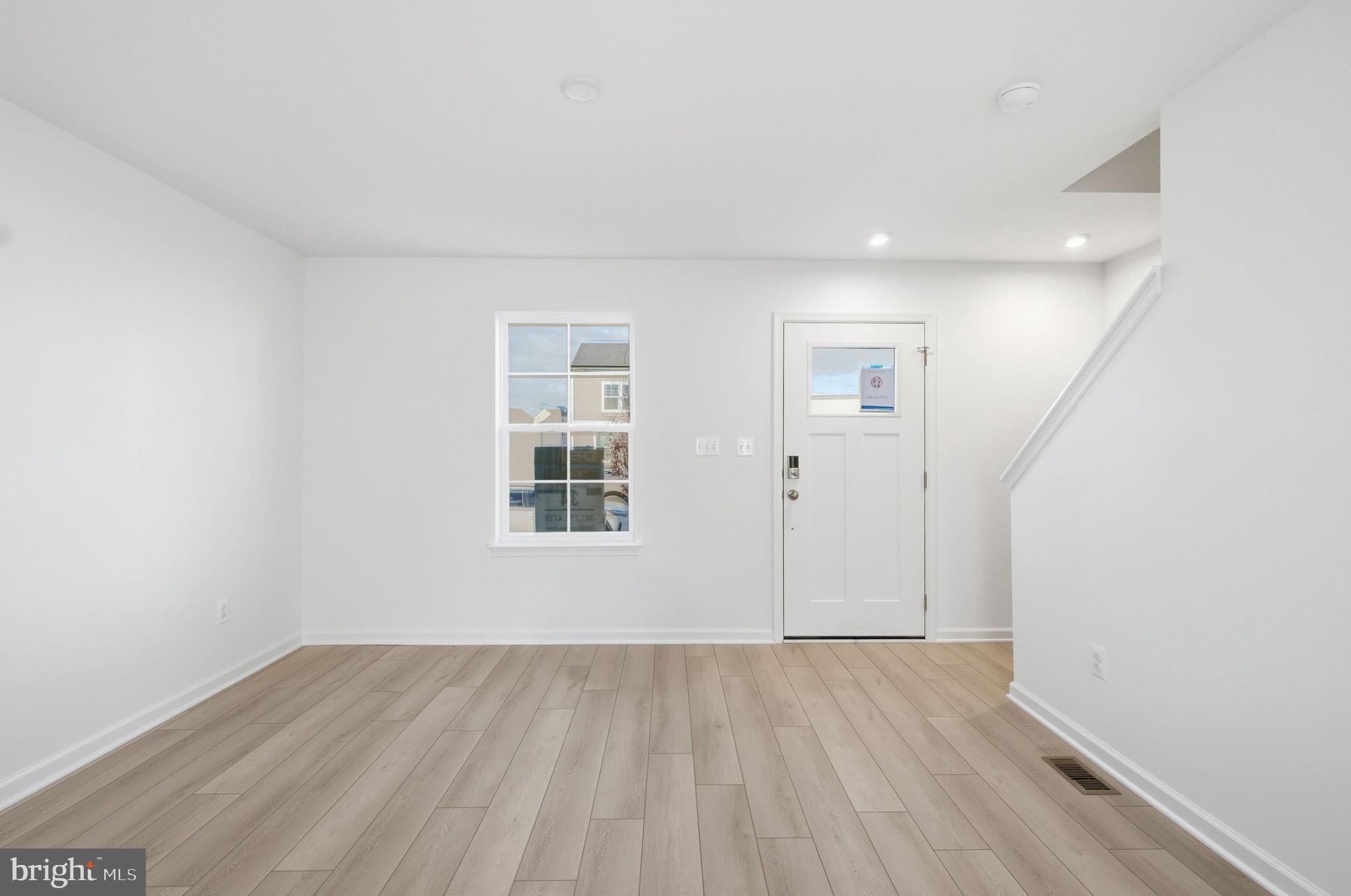 Tbb Tbb Outrigger Road, Unit WEXFORD Inwood, WV 25428 - Photo 10 of 34 an empty room with wooden floor and windows