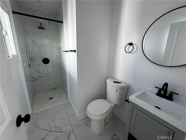 a bathroom with a toilet a sink a shower and mirror