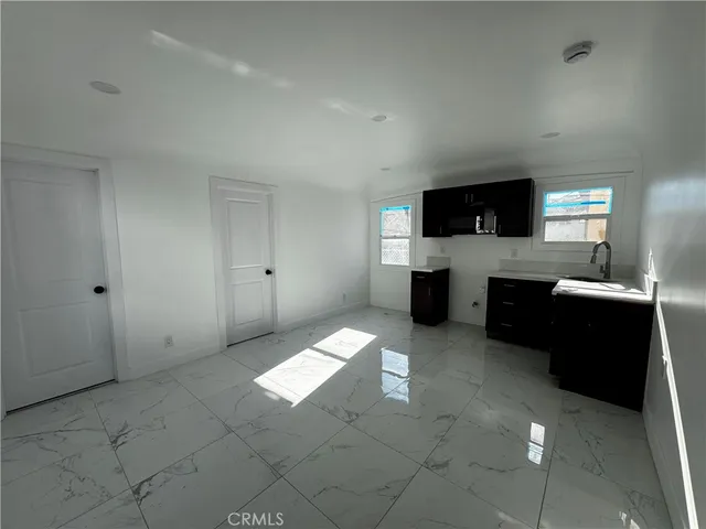 a living room with stainless steel appliances furniture a fireplace and a flat screen tv