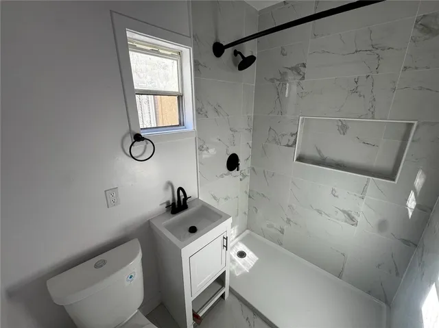 a bathroom with a sink a toilet and shower