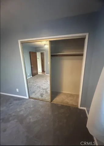 an empty room with closet and mirror