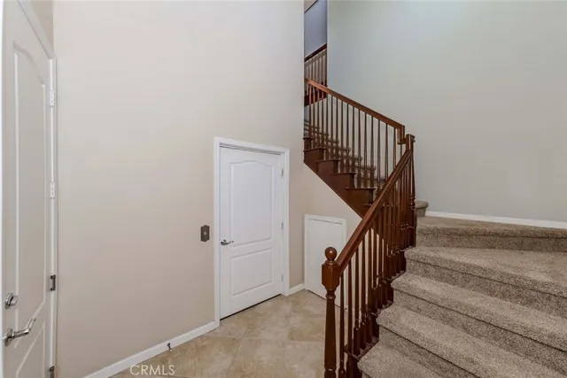 a view of staircase with railing and white walls