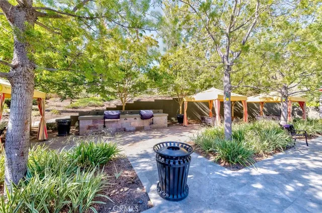 a view of a patio with table and chairs potted plants and large tree