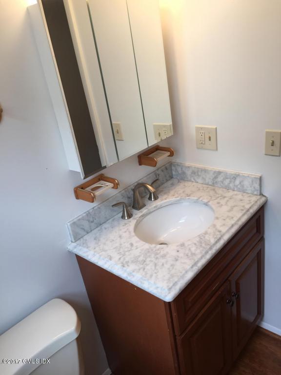 6 Booth Court, Unit B Greenwich, CT 06830 - Photo 4 of 9 a bathroom with a granite countertop sink a toilet and a mirror