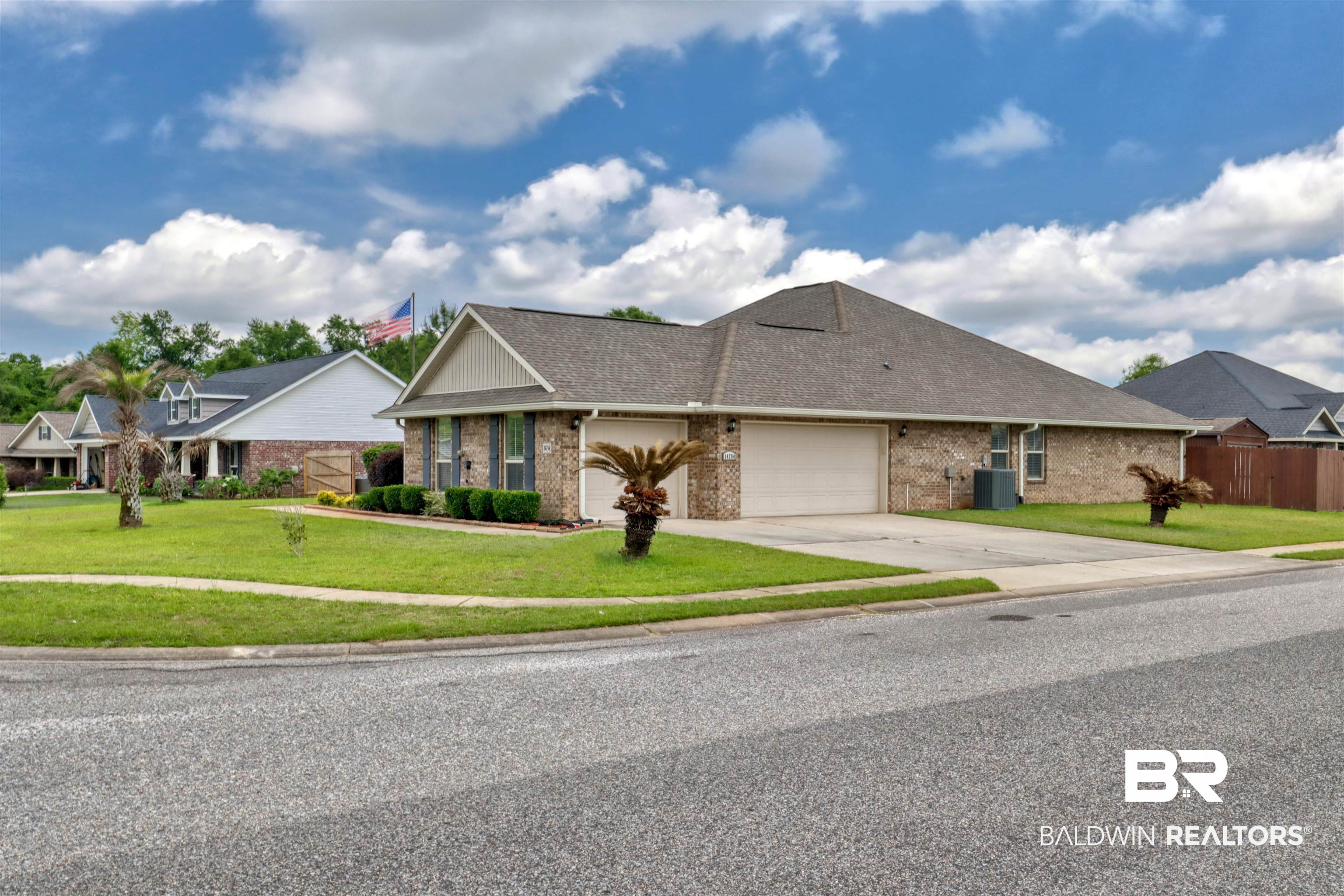 14794 Troon Drive Foley, AL 36535 - Photo 2 of 33 View of front facade with brick siding, a garage, a front yard, central AC unit, and driveway
