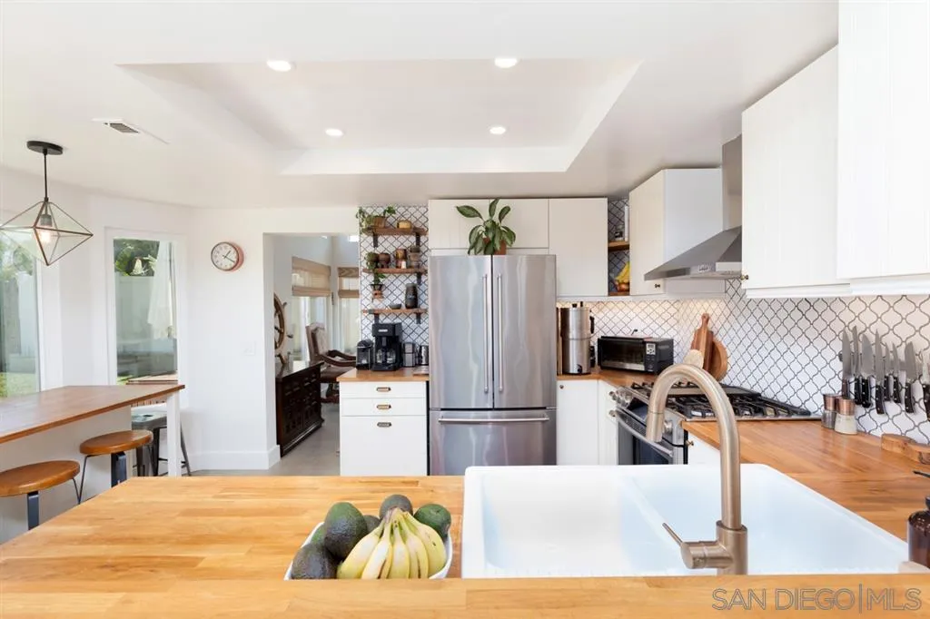 2112 Ramada Drive Oceanside, CA 92056 - Photo 7 of 25 a kitchen with stainless steel appliances kitchen island granite countertop a refrigerator and a stove top oven