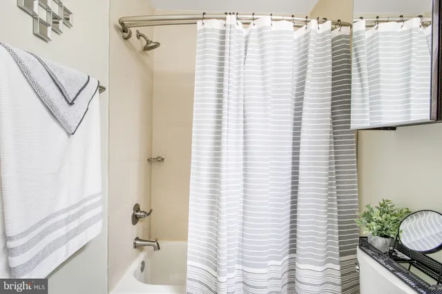 a bathroom with a granite countertop sink vanity mirror and toilet