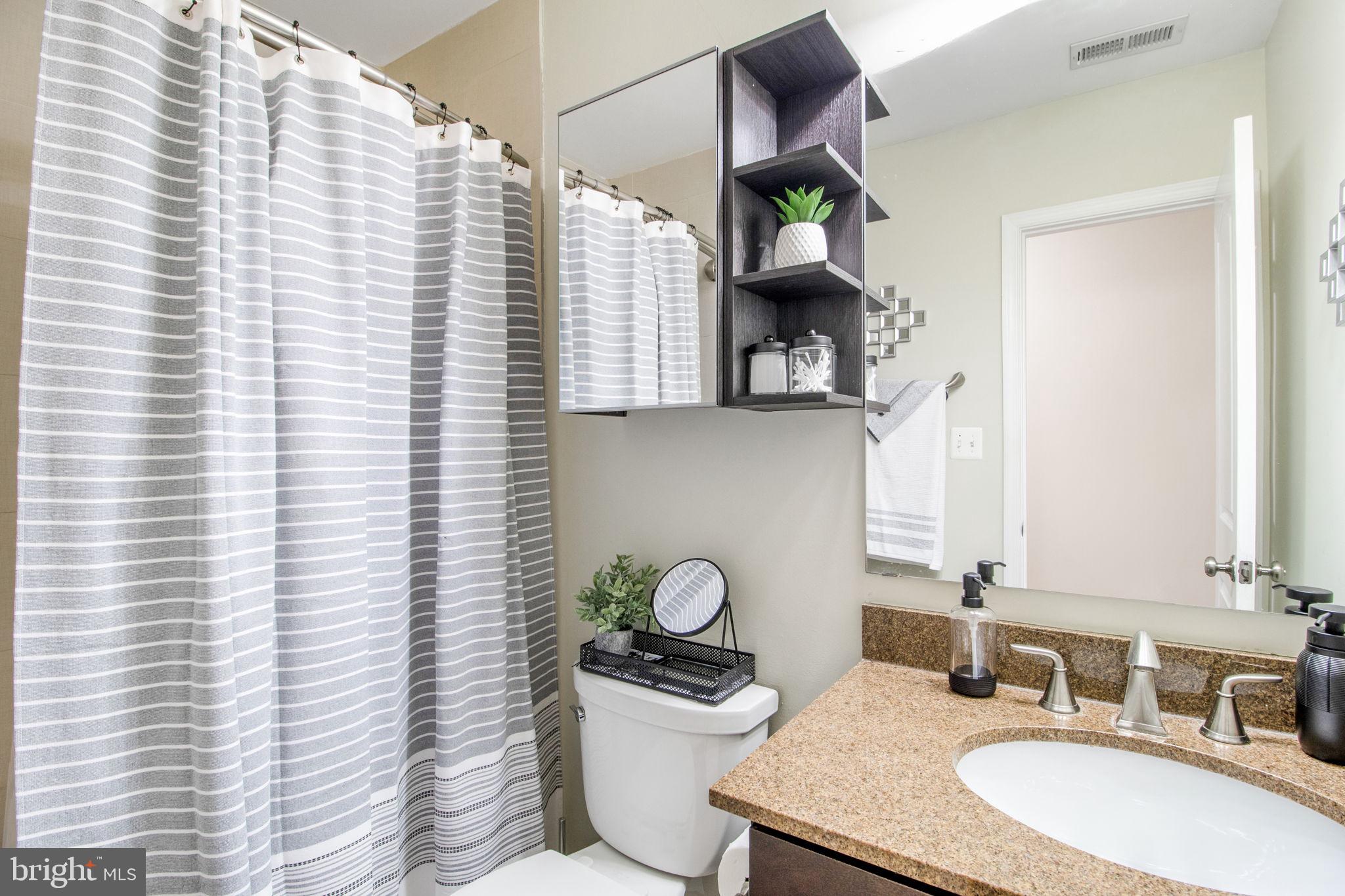 417 18th Street Northeast, Unit 101 Washington, DC 20002 - Photo 23 of 57 a bathroom with a granite countertop sink vanity mirror and toilet
