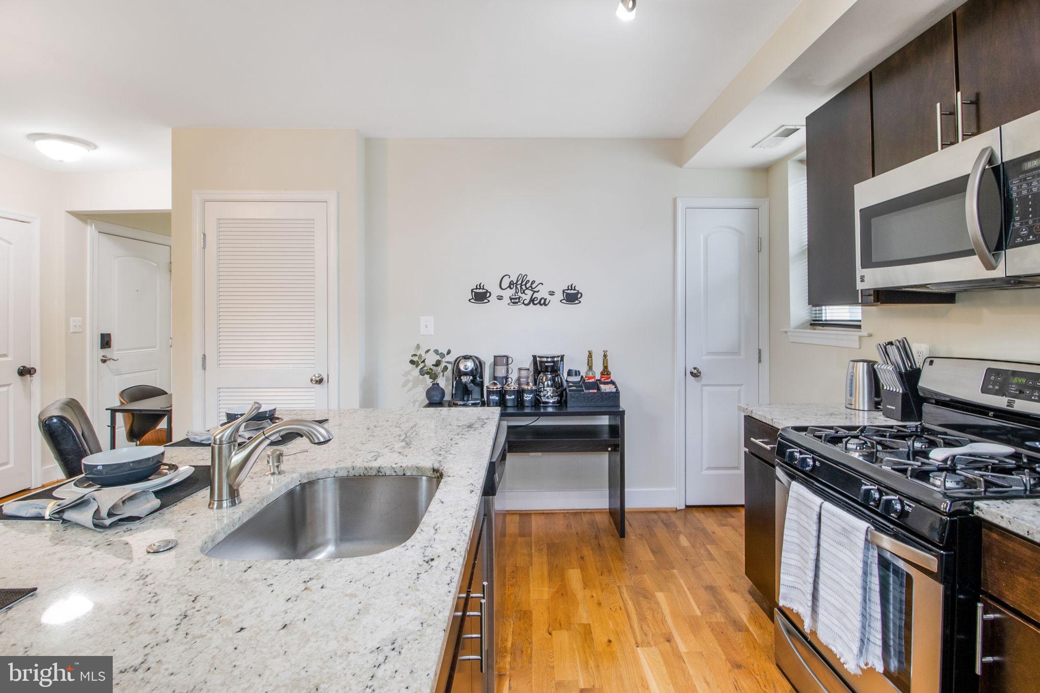 417 18th Street Northeast, Unit 101 Washington, DC 20002 - Photo 34 of 57 a kitchen with stainless steel appliances a stove a sink and a microwave