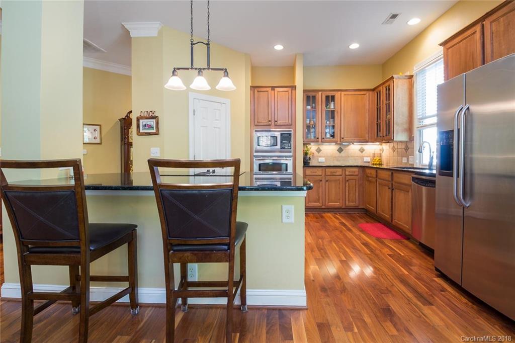 912 Gardenia Street Fort Mill, SC 29708 - Photo 14 of 32 a kitchen with stainless steel appliances granite countertop a refrigerator a stove a sink dishwasher with a dining table and chairs