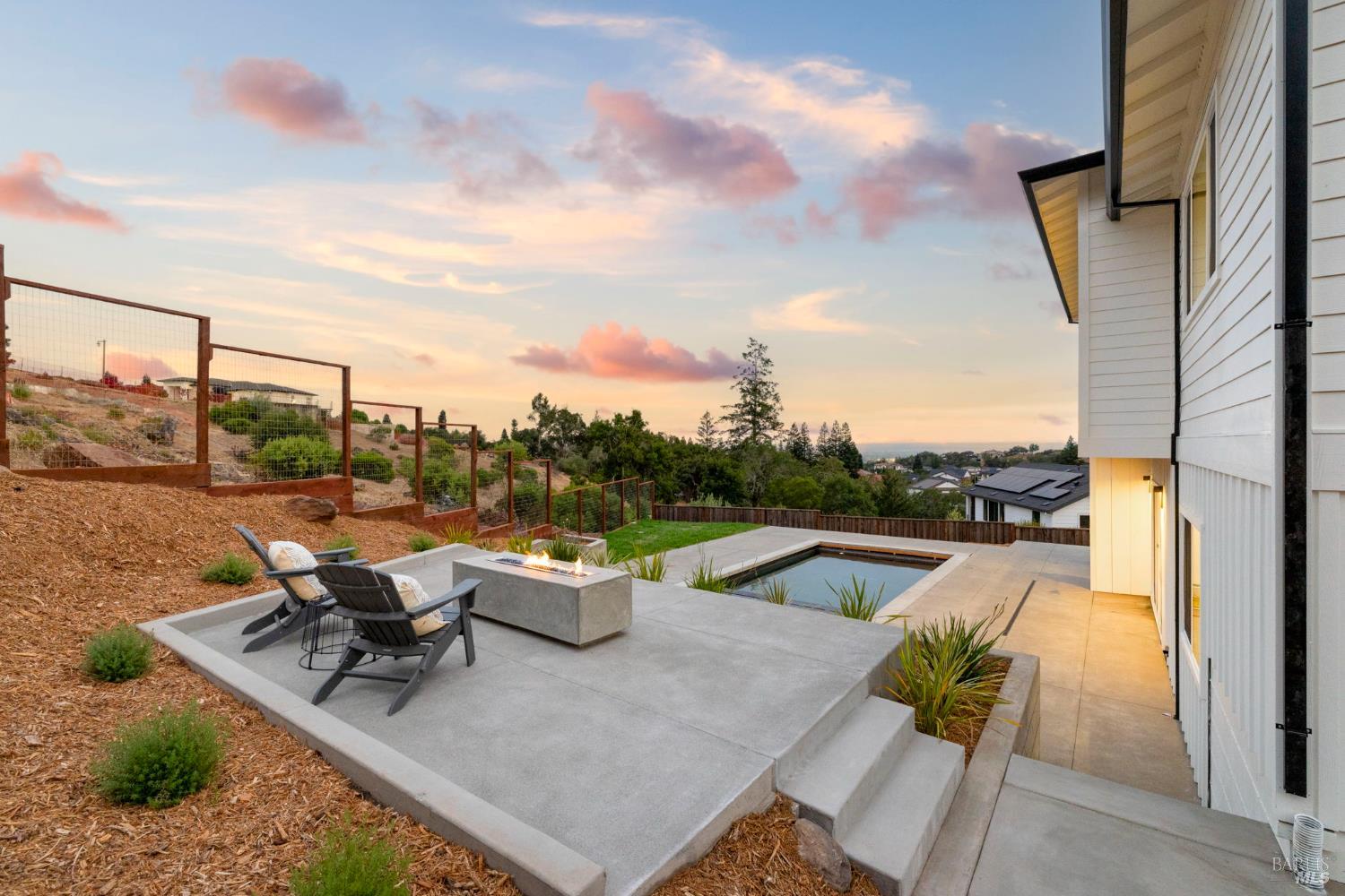 Backyard features fire pit, heated pool and hot tub.