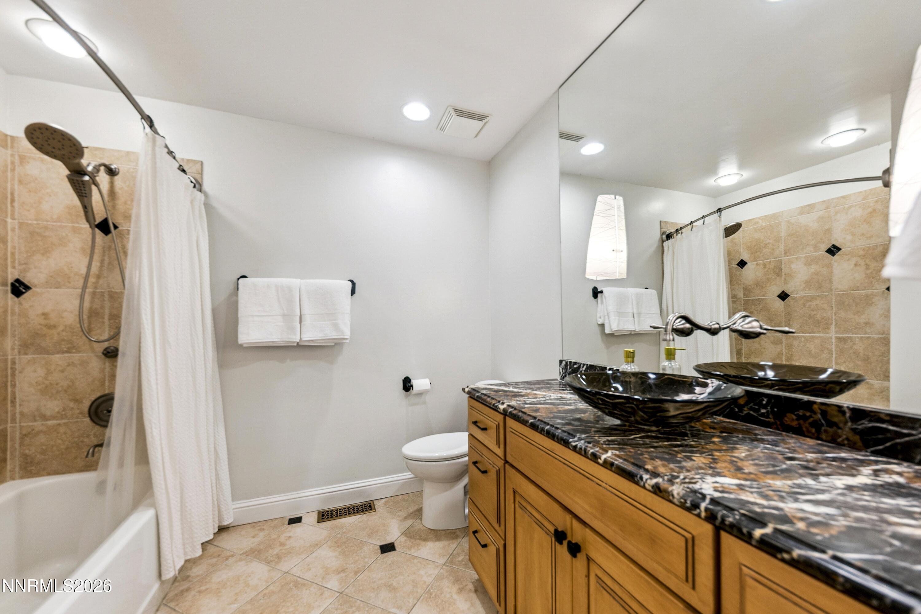 3620 East Hidden Valley Drive Reno, NV 89502 - Photo 35 of 67 a bathroom with a granite countertop sink a toilet a mirror and shower