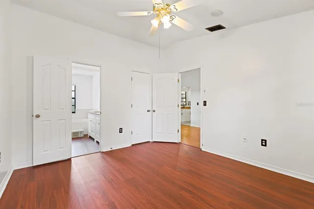 an empty room with a window and a ceiling fan