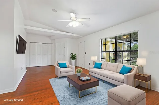 a view of empty room with wooden floor and fan