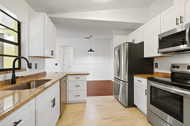 a view of a room with wooden floor and a ceiling fan