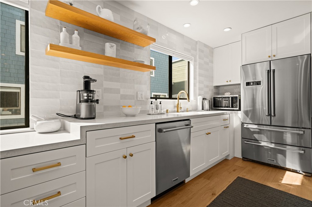 3716 Vía Dolce Marina del Rey, CA 90292 - Photo 15 of 55 a kitchen with white cabinets and stainless steel appliances