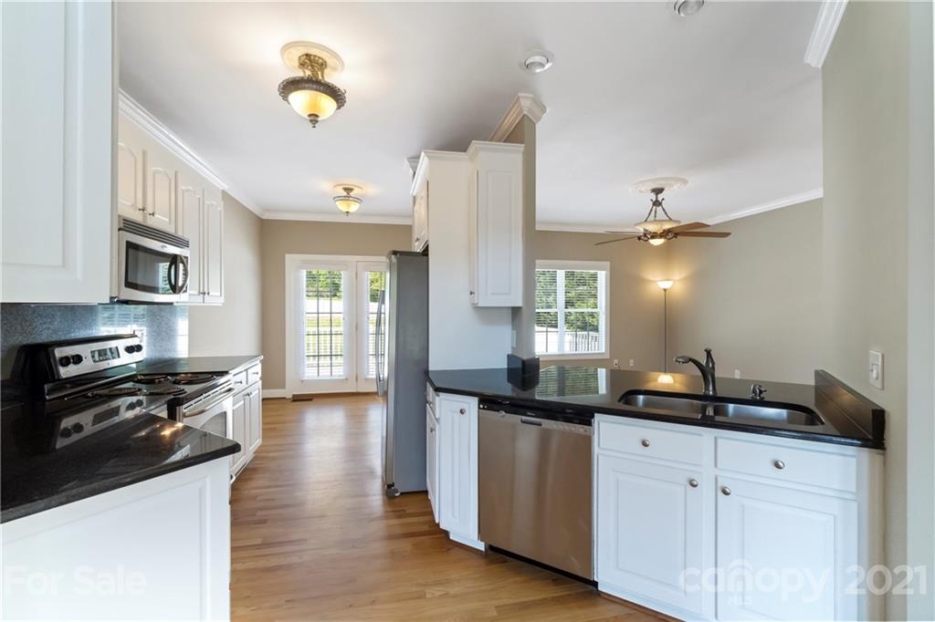 1466 Victorian Hills Circle Conover, NC 28613 - Photo 8 of 40 a kitchen with granite countertop a sink cabinets and stainless steel appliances