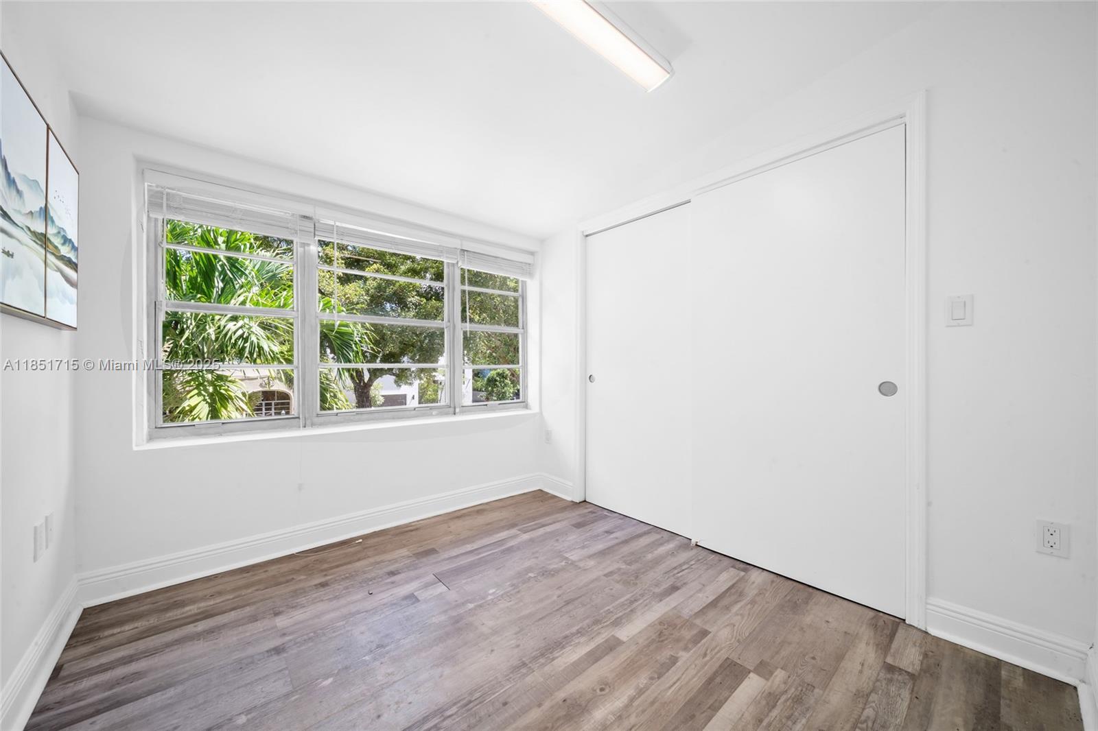 1520 Southwest 11th Terrace, Unit B Miami, FL 33135 - Photo 21 of 32 an empty room with wooden floor and windows