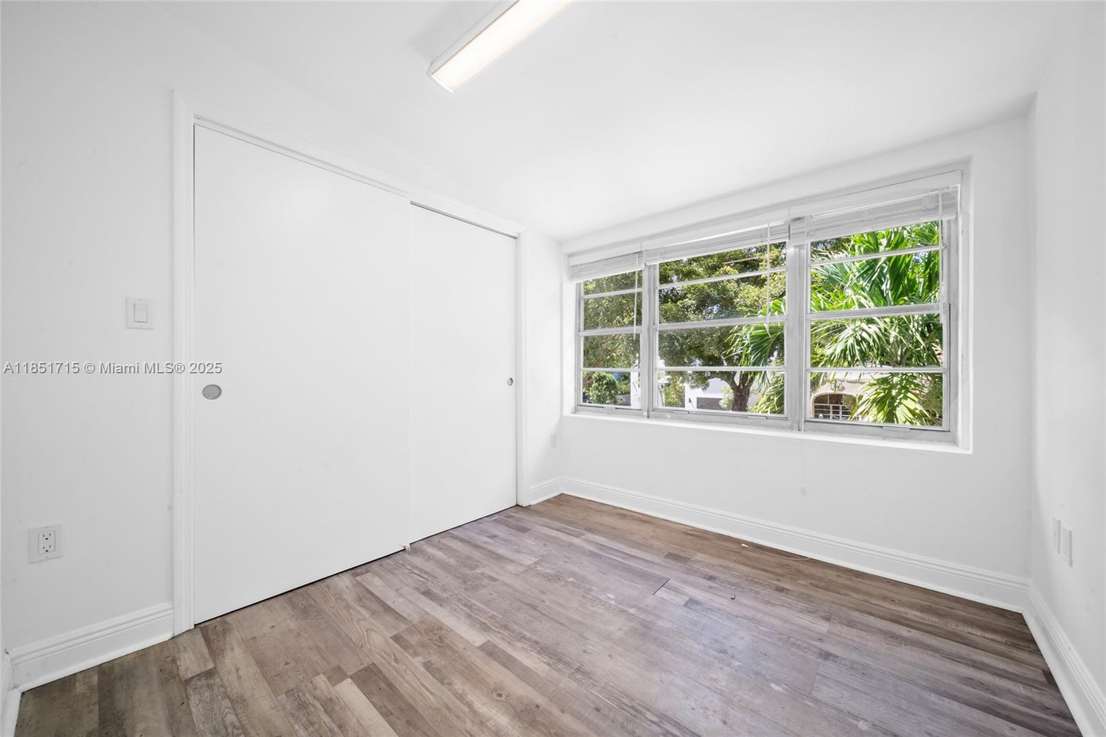 1520 Southwest 11th Terrace, Unit B Miami, FL 33135 - Photo 22 of 32 an empty room with wooden floor and windows