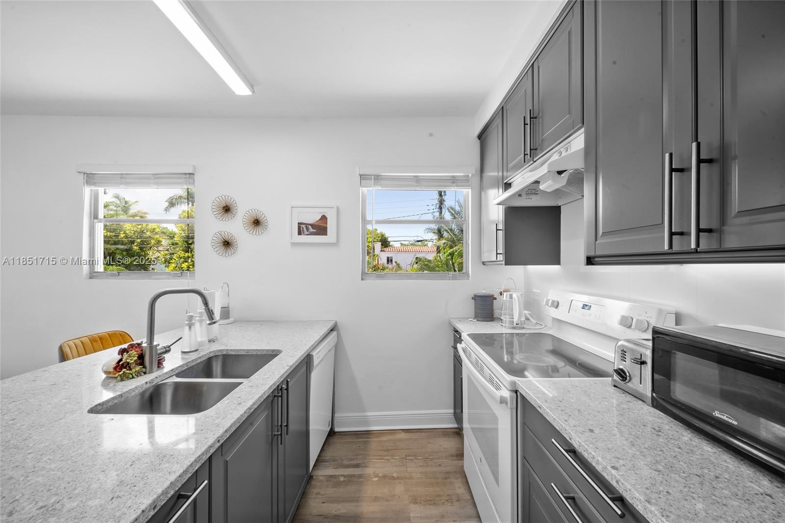 1520 Southwest 11th Terrace, Unit B Miami, FL 33135 - Photo 8 of 32 a kitchen with a sink stove top oven and cabinets