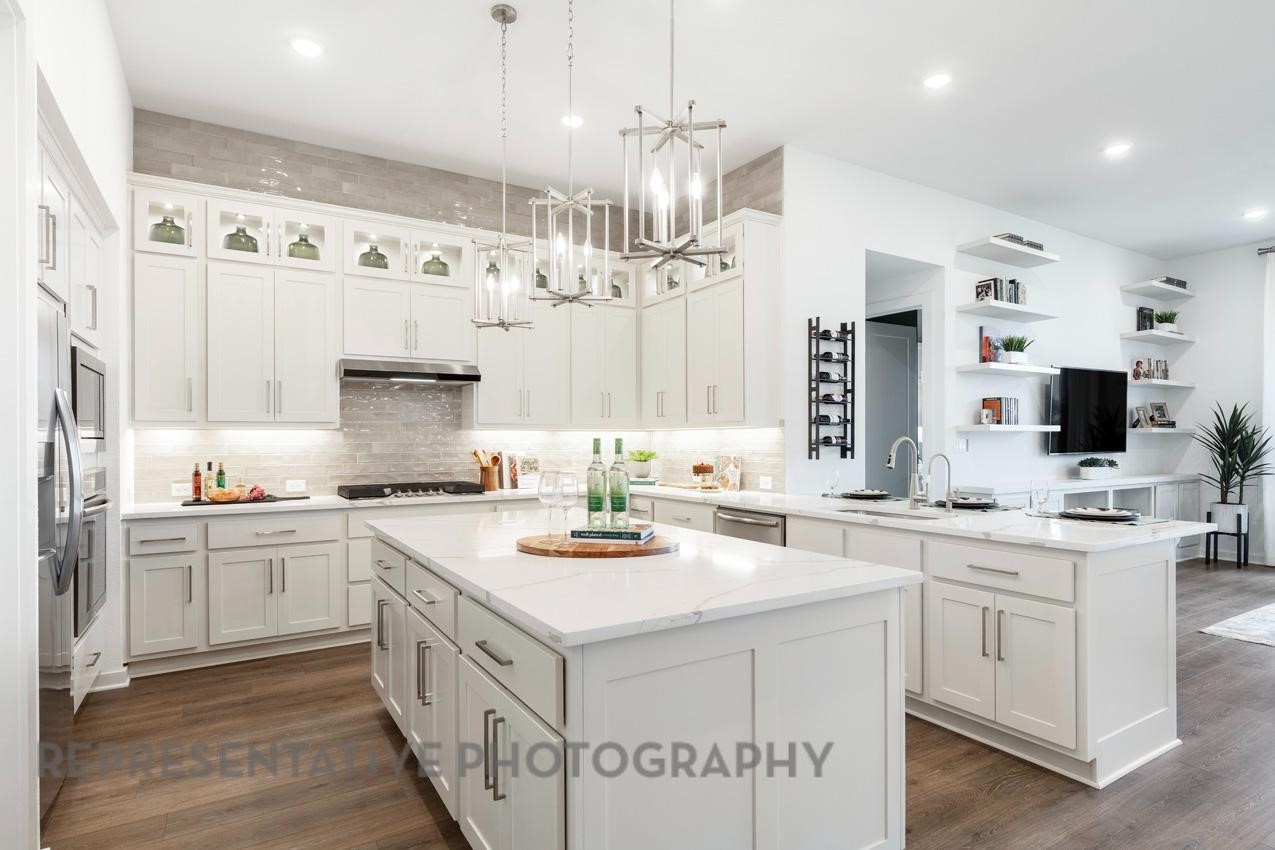 2714 Peach Vly Road Fulshear, TX 77423 - Photo 3 of 47 a kitchen that has a lot of cabinets in it and wooden floors