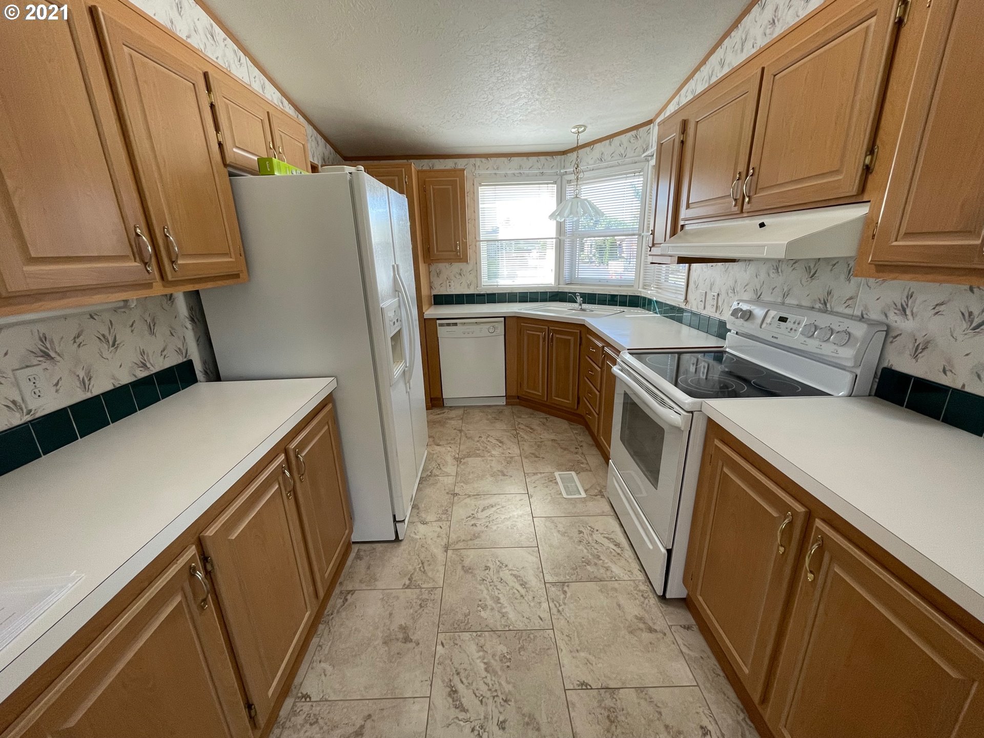 2150 Laura Street, Unit 61 Springfield, OR 97477 - Photo 14 of 24 a kitchen with a refrigerator a sink and a stove