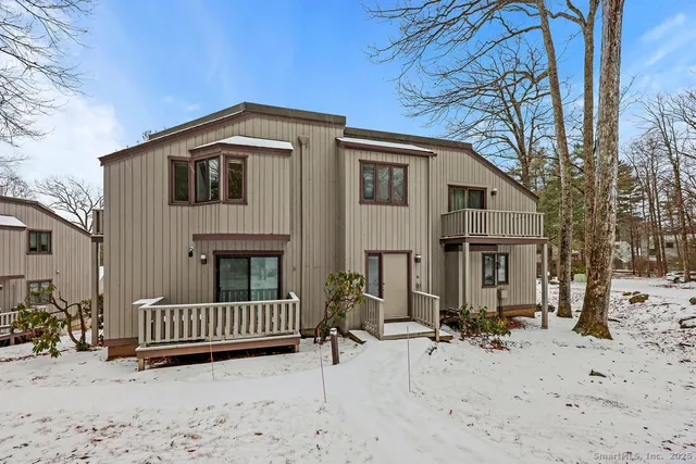 a view of a house with a yard and large tree