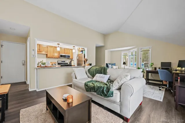 a living room with furniture and a wooden floor