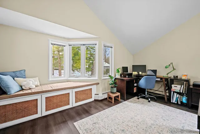 a view of a workspace with furniture and a window