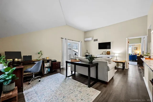 a view of a workspace with furniture and a window